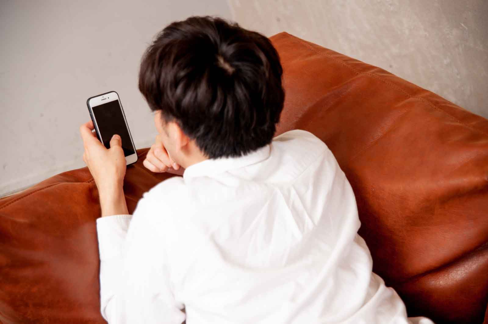スマホを見るゲイの若者